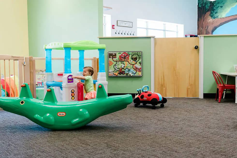 Pretend-play fire station with an indoor slide and turf play area at LADYBUGS Play in Fairport.