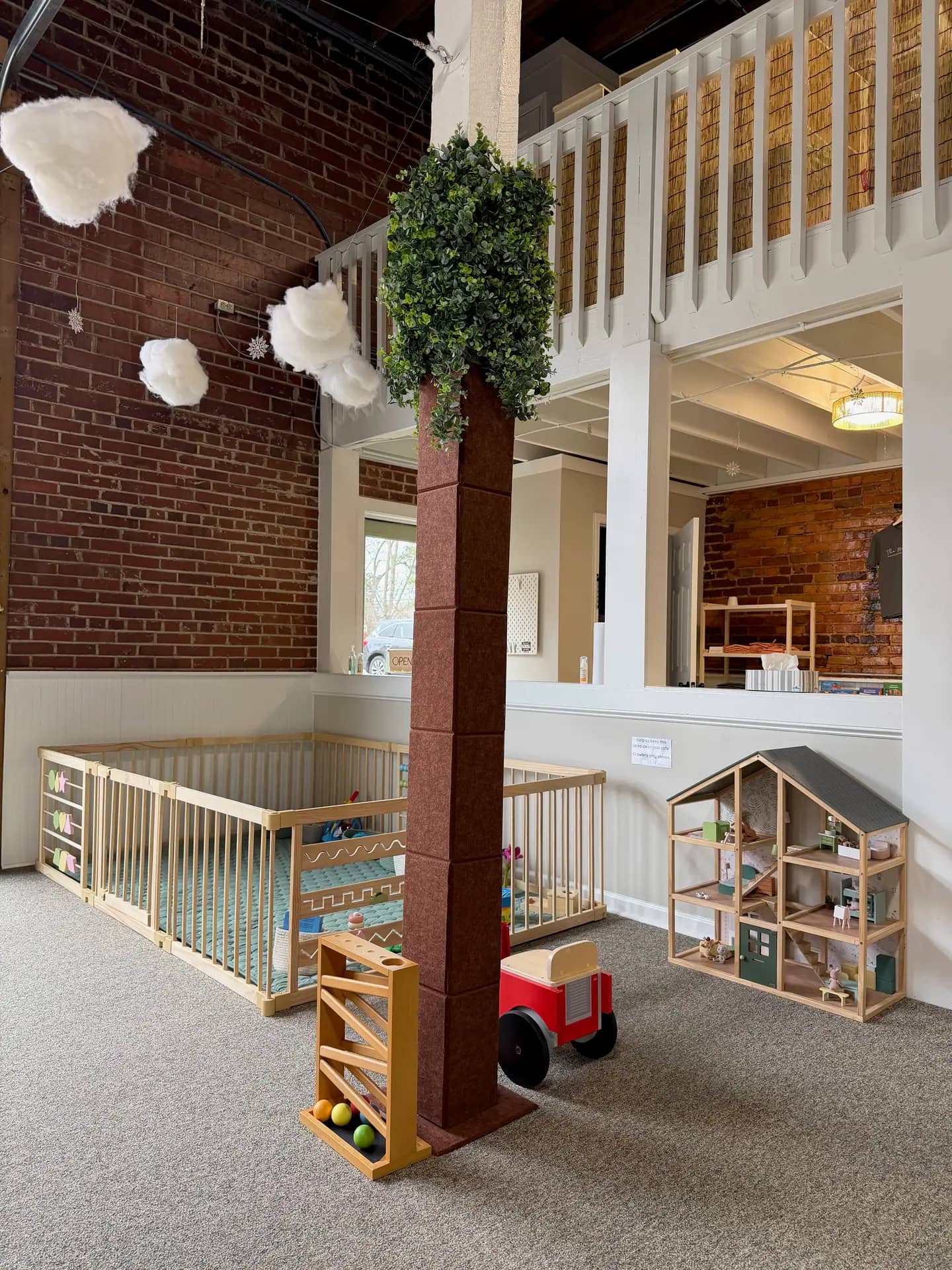 Toddler-friendly play area with fenced baby zone and dollhouse at The Meadow Montessori Play Studio