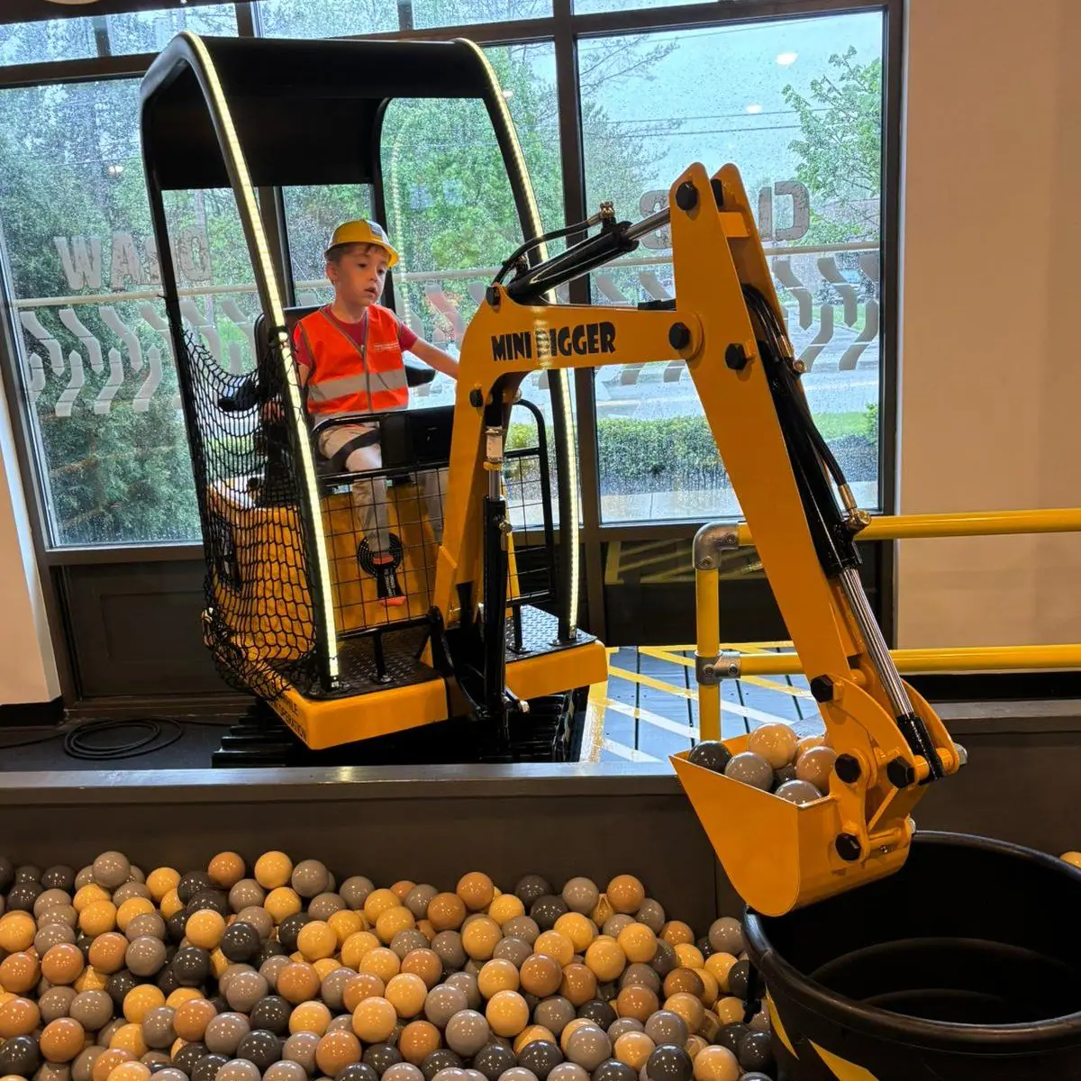 Child operating a digger-style play feature inside Construction Corner in Powell.