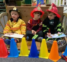 Children in firefighter hats during a museum activity at Cape Cod Children's Museum.