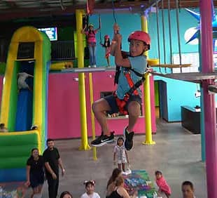 Child riding the Sky Trail or zip-style course at Jumbo Park Texas Adventure.