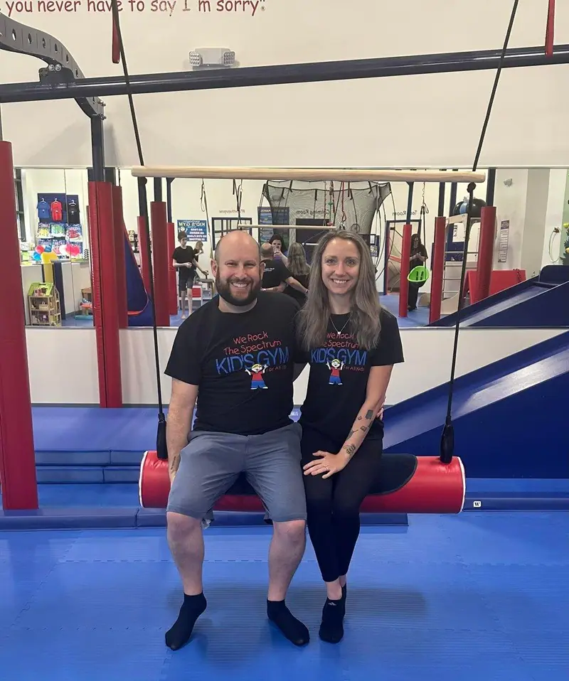 Family-friendly gym space with suspended equipment and padded flooring at We Rock the Spectrum Cary.