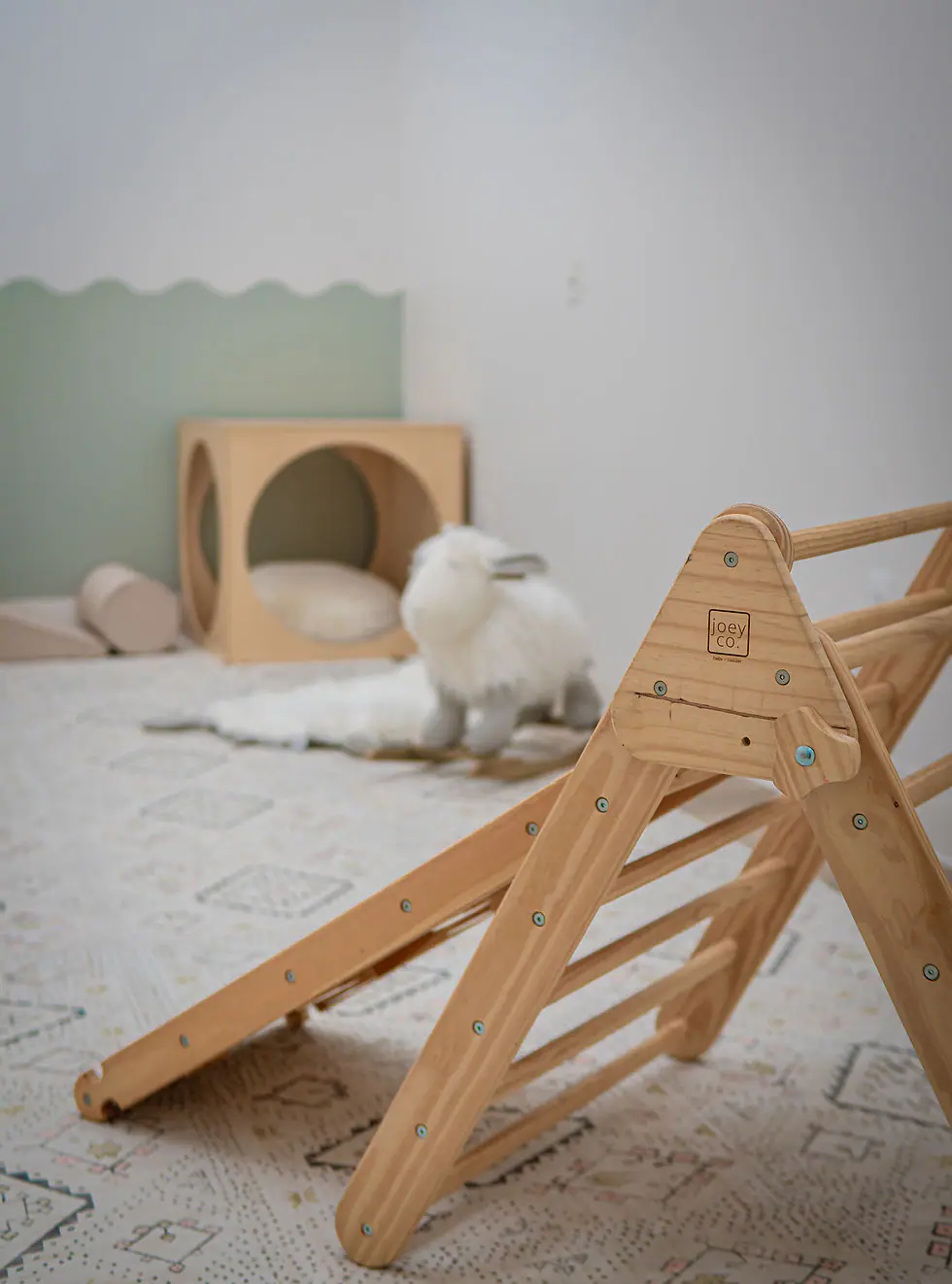 Wood climber and infant-friendly play area at Happy Baby Play.
