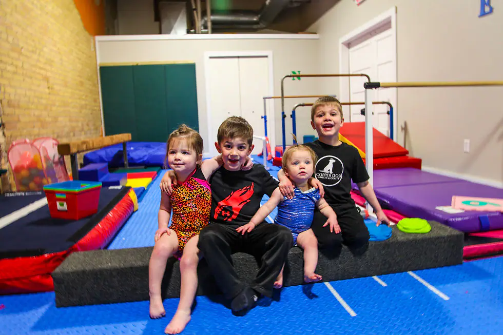 Children playing on gymnastics-style equipment at Mini Gym in Mandan