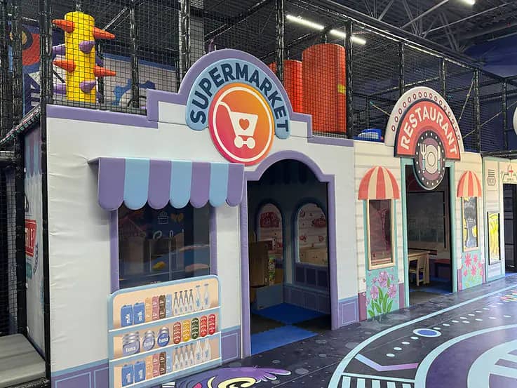 Pretend-play storefronts inside the toddler area at The Play Space Sugar Land.