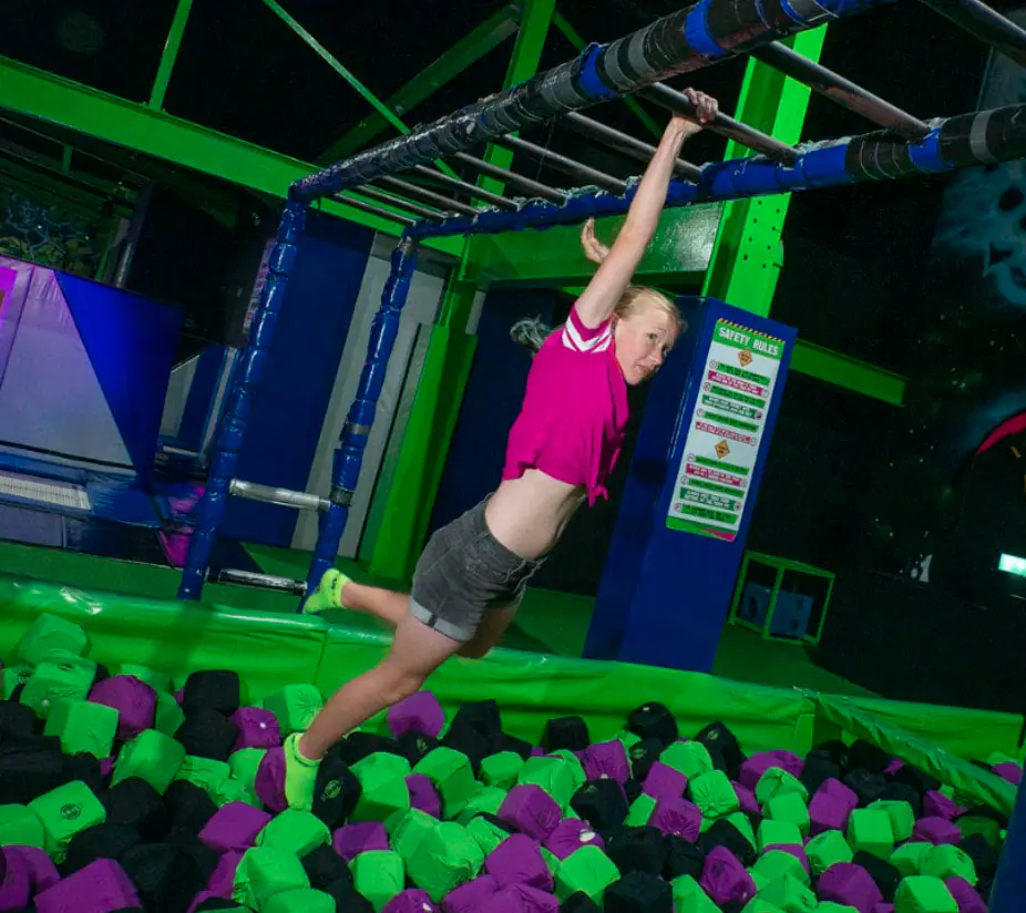 Child swinging over a foam pit obstacle at Play Lab