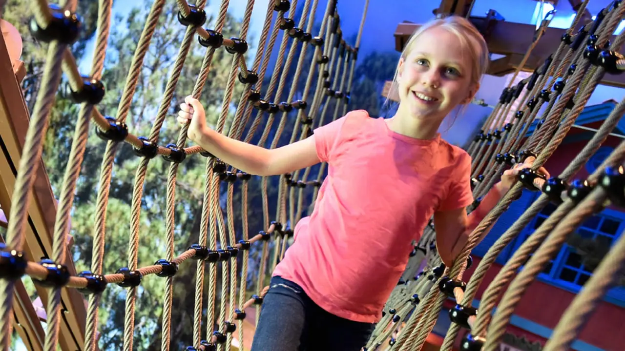 Child crossing rope-bridge elements at Howler's Peak Adventure Trail at Great Wolf Lodge Mashantucket.