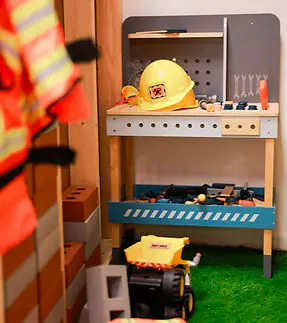 Play House Chester construction play area with toy tools and vehicles.