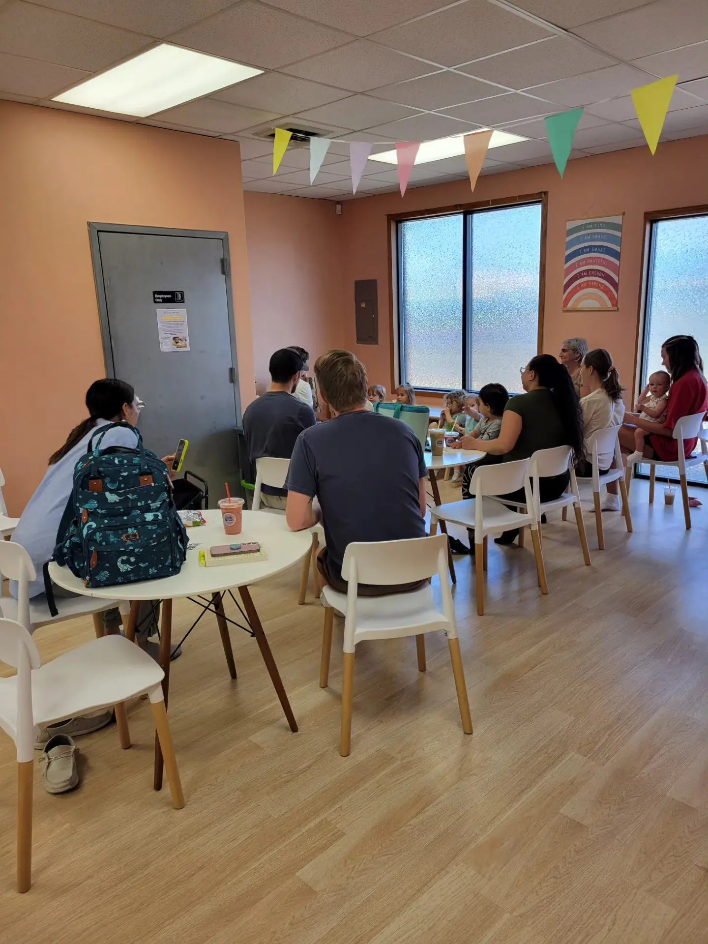 Tables and seating area for caregivers inside Little Beans Play Café.