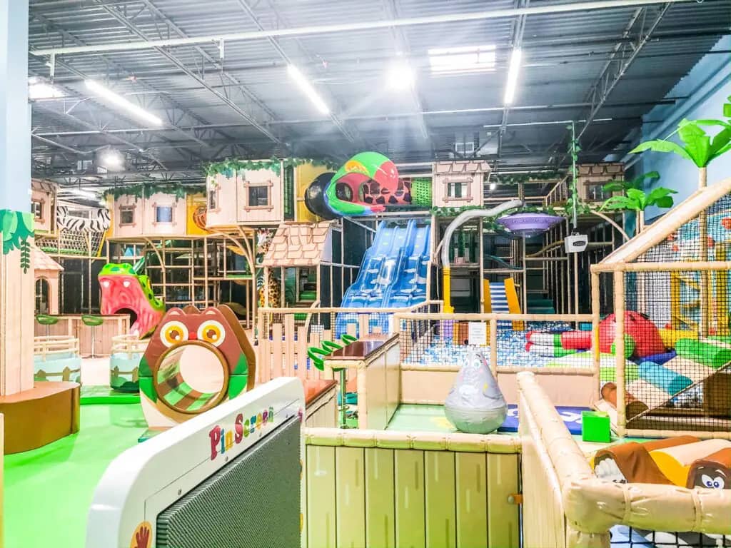 Children playing inside the large indoor play structure at Me Land - Frederick.