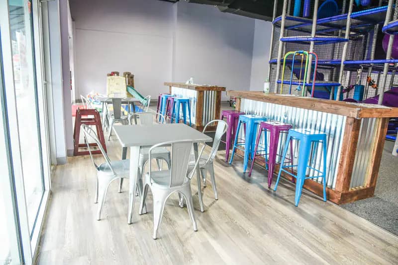 Café-style seating area inside InPlay! Family Fun with tables near the play space.
