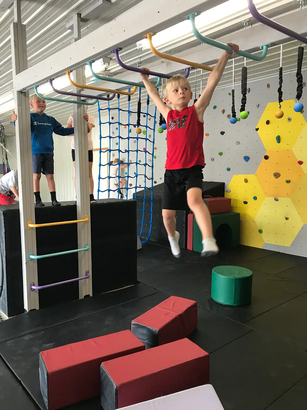 Children using monkey bars and climbing elements during an event at Happy Hive.