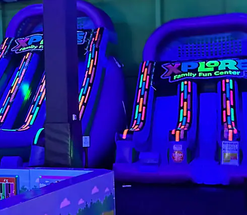 Glow-style slides and attractions inside Xplore Family Fun Center.