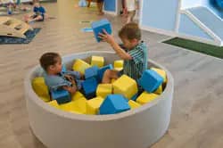 Children playing in a round foam-block pit at To The Stars Play Cafe.