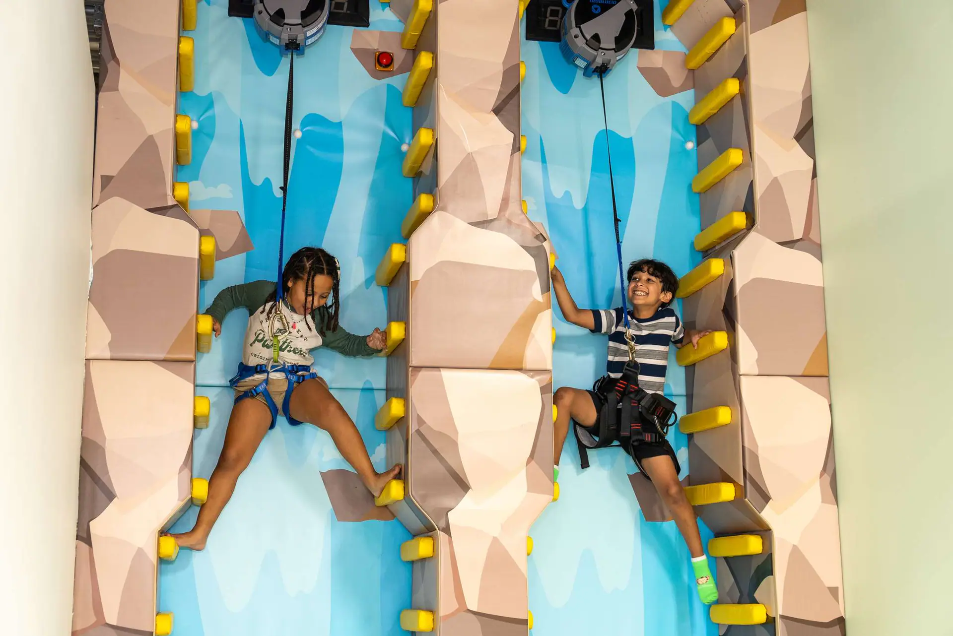 Children climbing and exploring the jungle-themed play structure at The Tree House Fort Lauderdale.