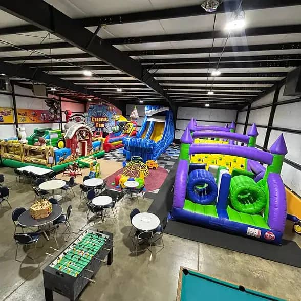 Indoor inflatable play area with bounce houses, slides, and seating at VC Jump and Slide in Sioux City.