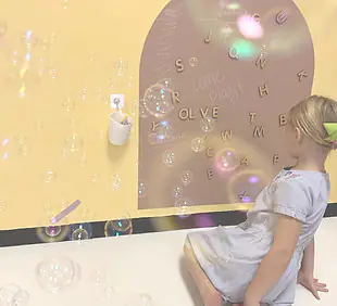 Child playing with bubbles inside The Playroom in Morgantown.