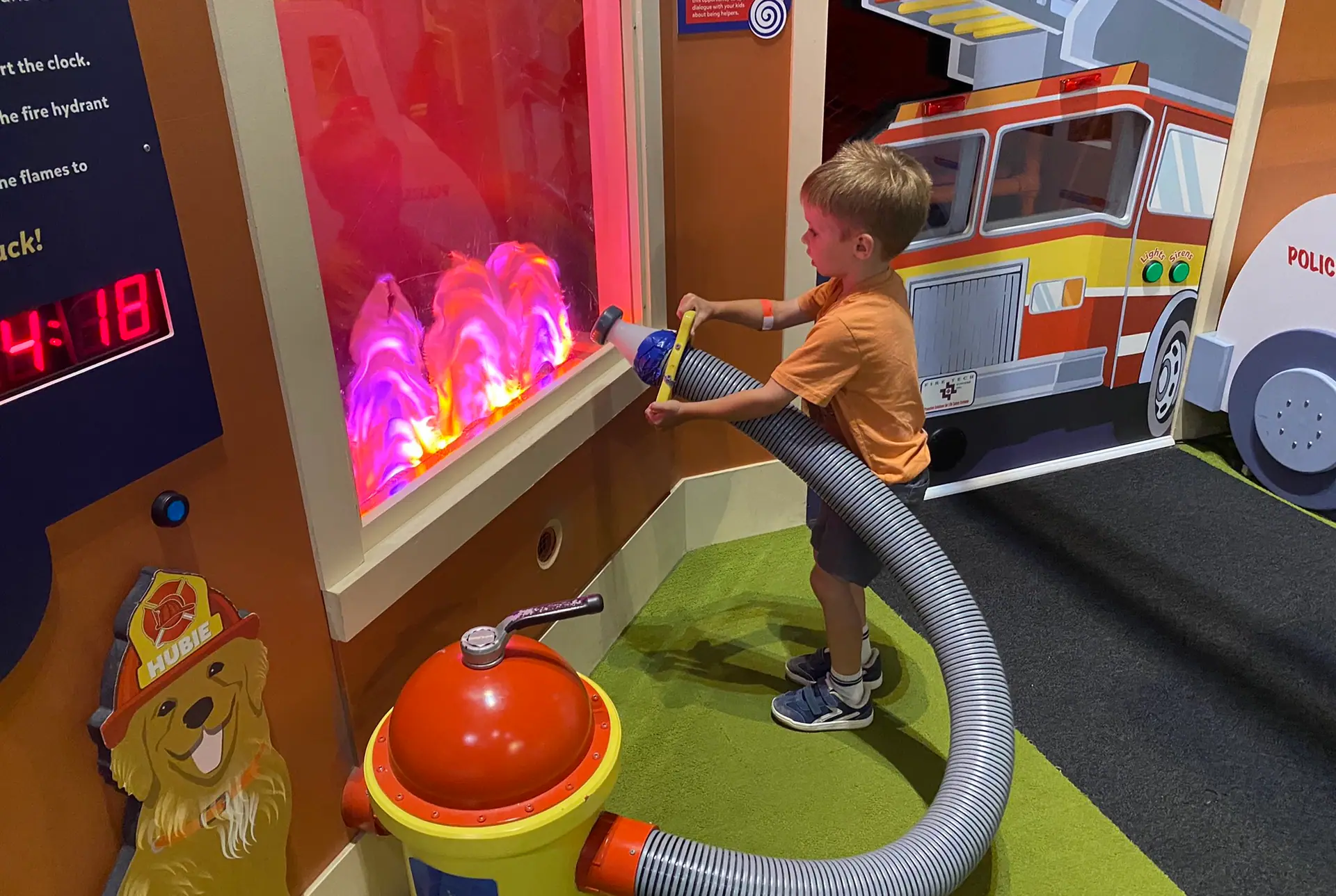 Child using the firehouse-style interactive exhibit at PoP Children’s Museum.
