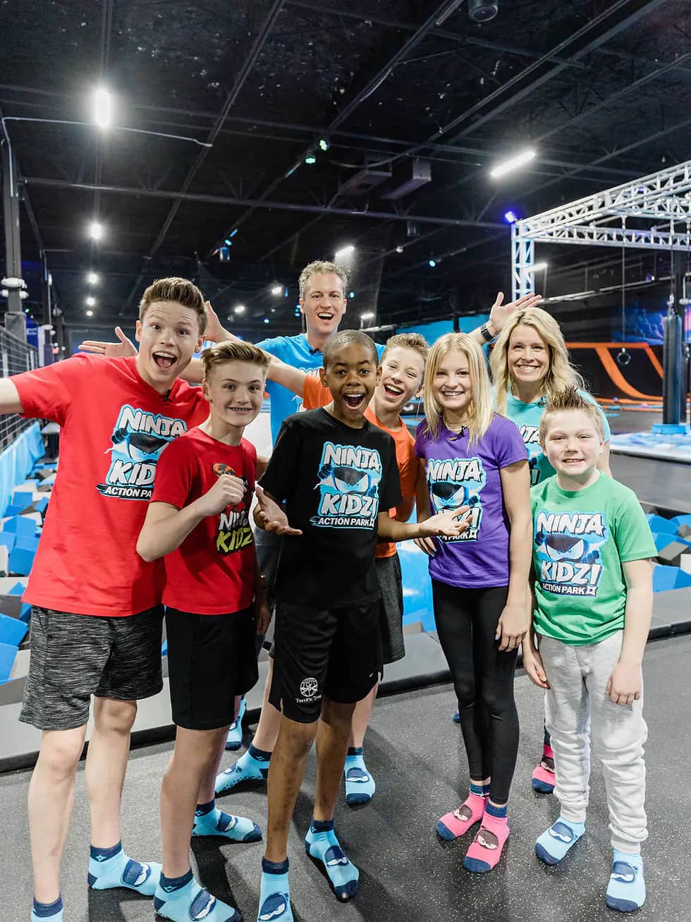 Children playing across trampolines and active obstacles at Ninja Kidz Action Park.