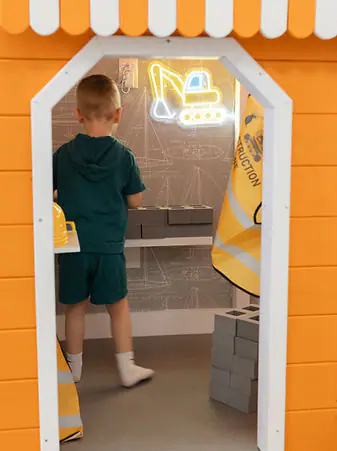 Construction-themed pretend-play nook inside Happy Days Play Cafe