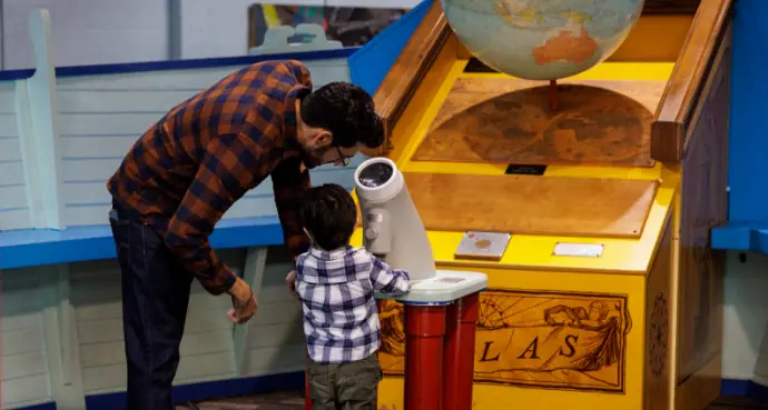 Adult and child using an interactive exhibit at Discovery Science Place.