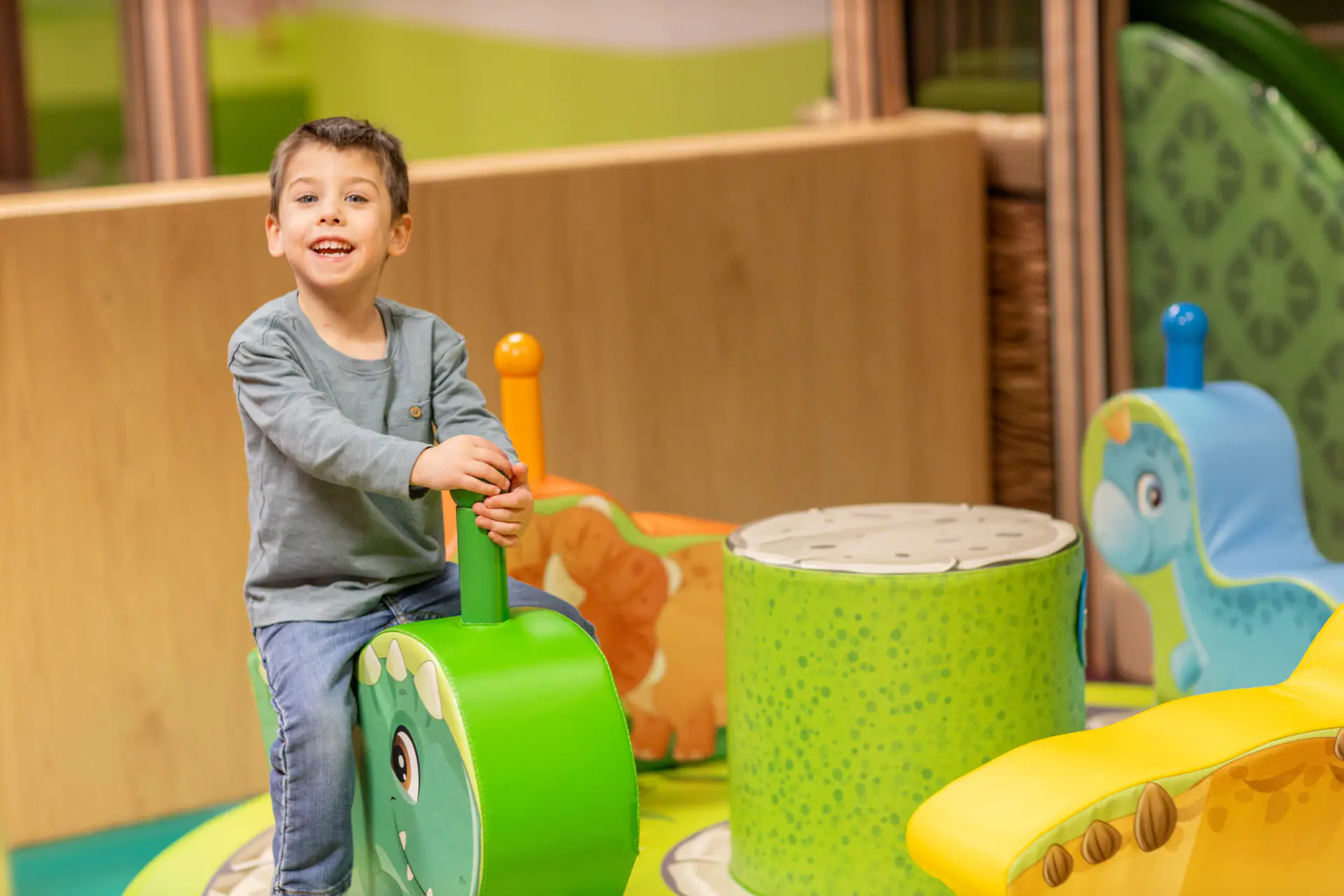 Child riding a play toy in the toddler area at Impact Kids.