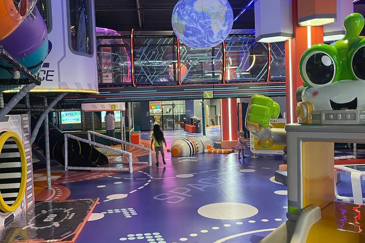 Open play floor with space-themed structures at Catch Air Jersey City.