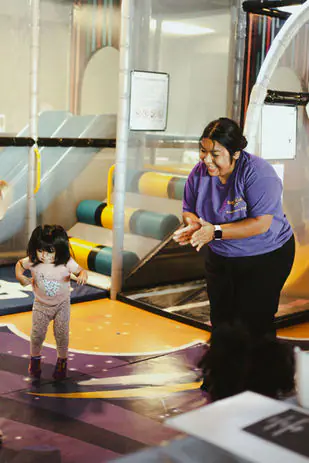 Young child with a staff member inside the SuperKidz Club playground
