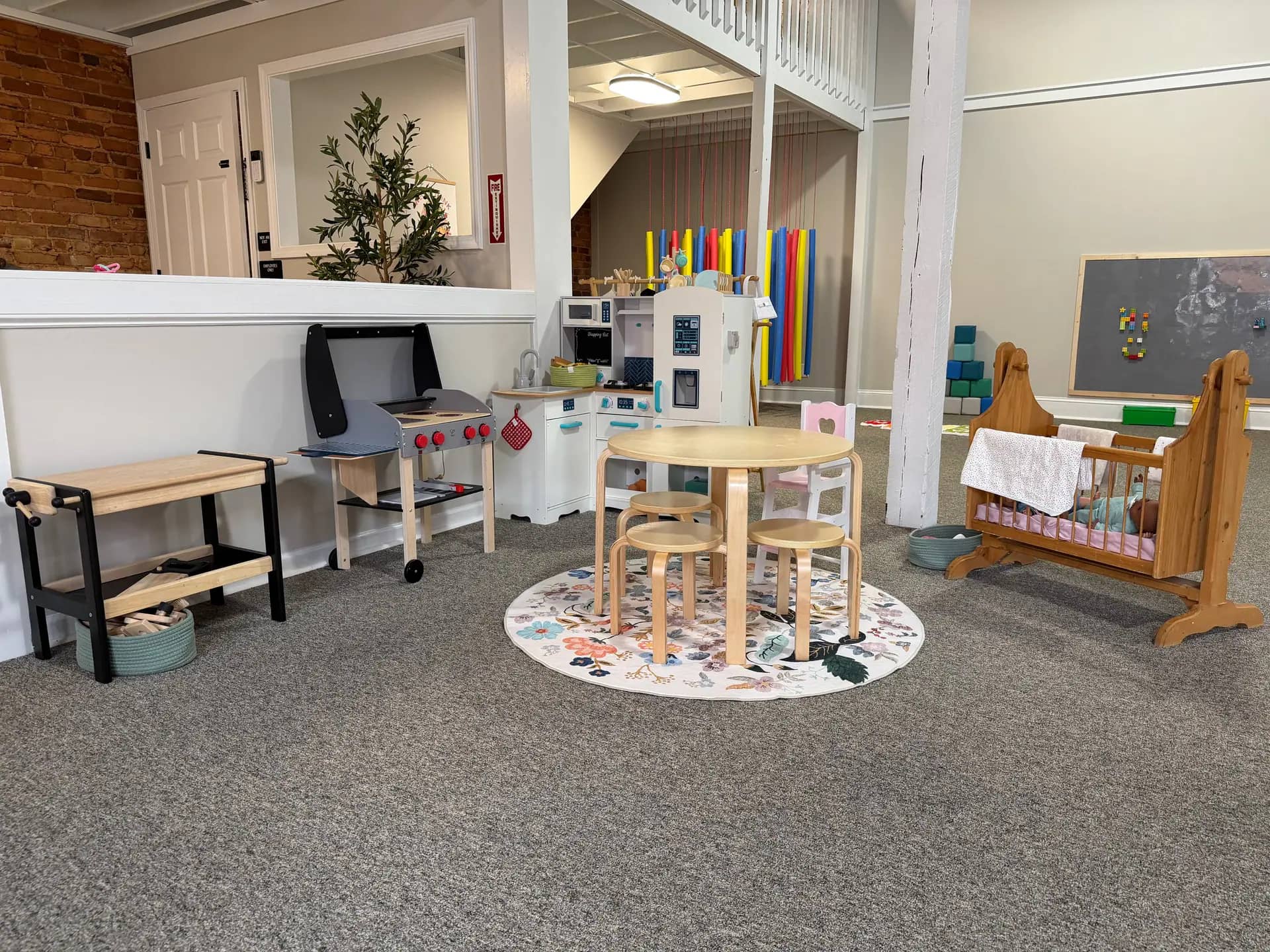 Pretend-play kitchen and toy area inside The Meadow Montessori Play Studio