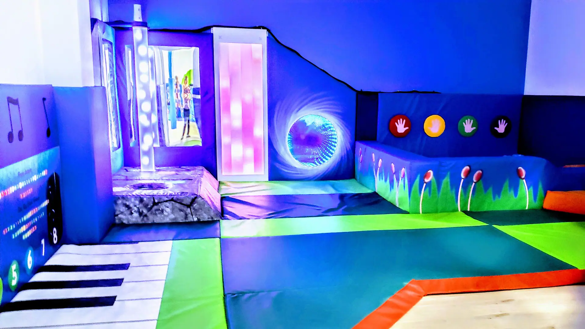 Sensory room with soft mats and light features at Indigo Play.