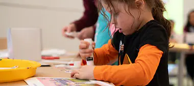 Families participating in a hands-on activity inside Bronx Children's Museum.