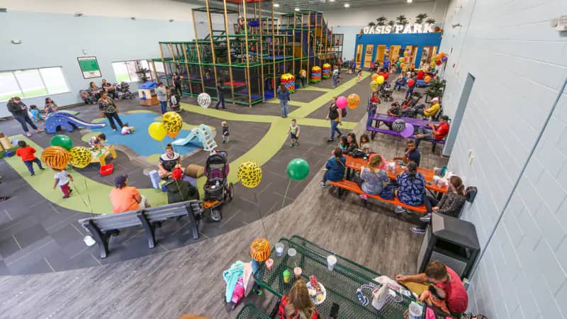 Children playing on the large indoor climbing structure at Oasis Park in Lafayette.