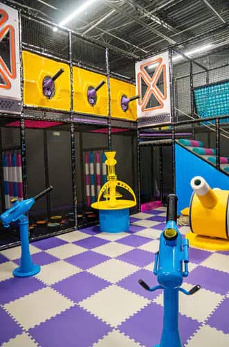 Colorful activity zone with interactive play cannons and soft flooring at Kidzville Nottingham.