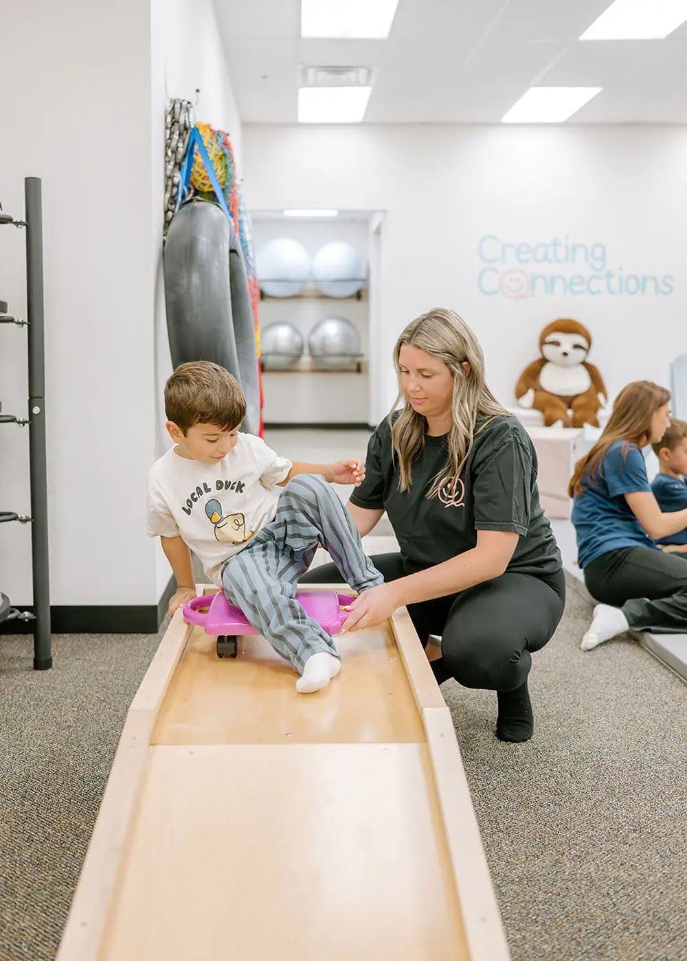 Caregiver and child using a play element at Creating Connections.