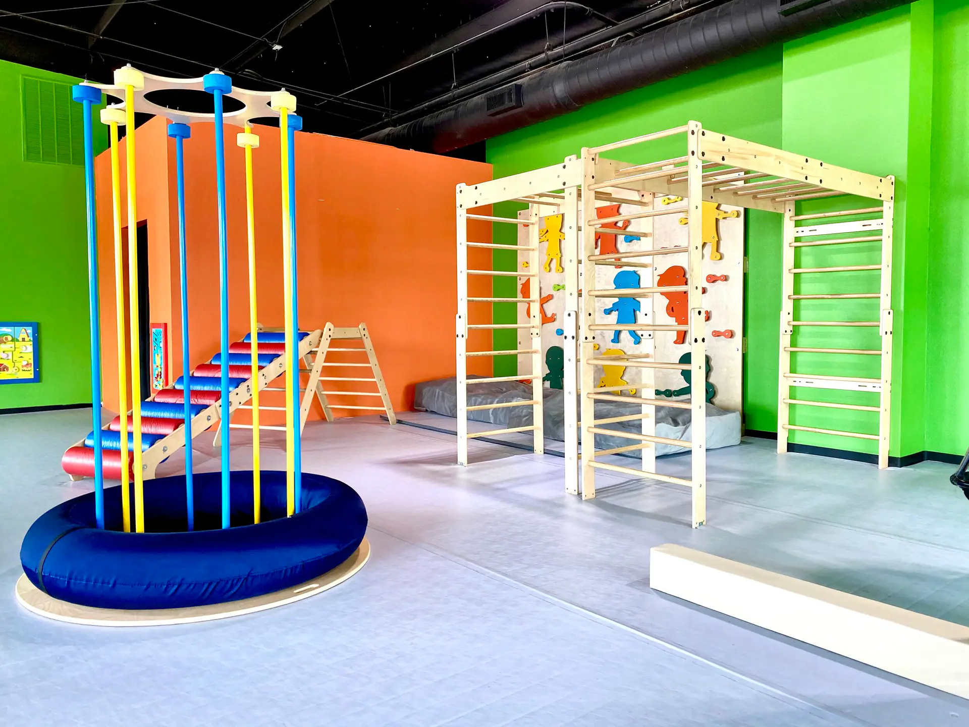 Climbing and movement area at Little Land Cedar Park with colorful gross-motor equipment.