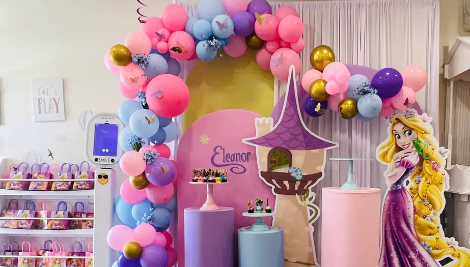 Themed birthday setup at Party Play Cafe with pastel balloon arch and party backdrop.