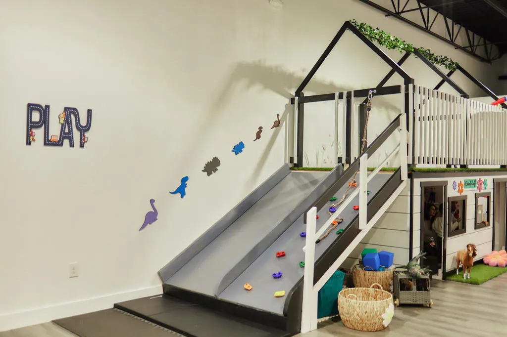 Play area and cafe seating inside Dino Daisy Play Cafe in Byron Center.