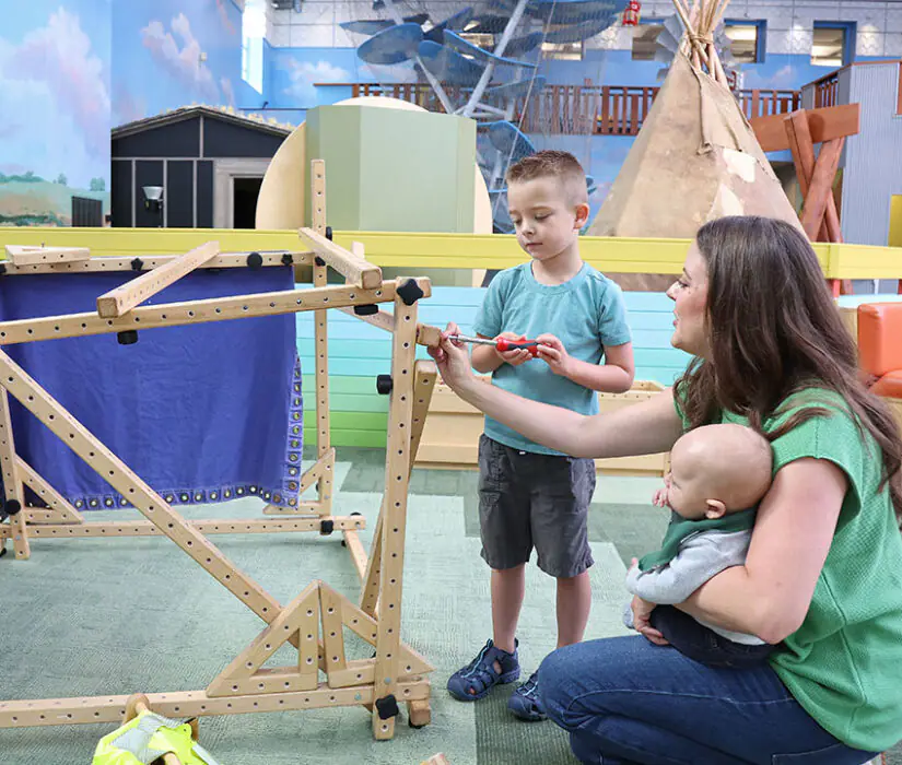 Caregiver and child building together in the Building Square exhibit at the Children's Museum of South Dakota.
