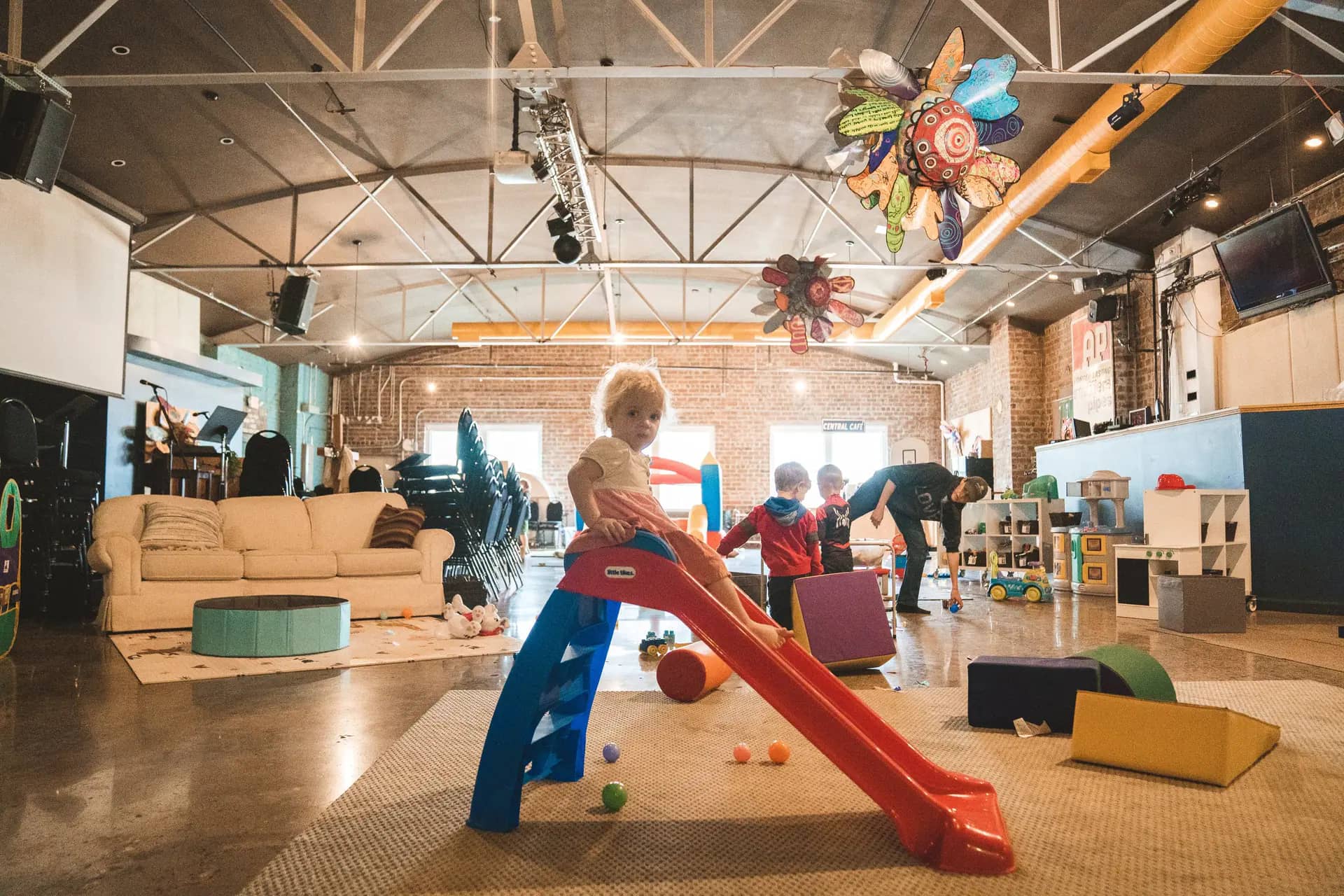 Open indoor play setup at Central Play Cafe with toys, soft-play pieces, and caregiver seating.