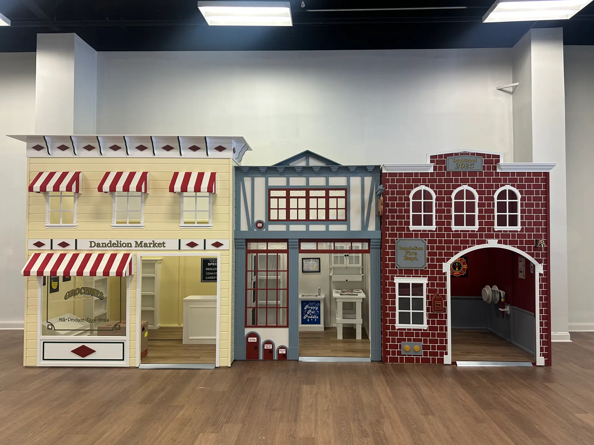 Kid-sized pretend-play storefronts inside Dandelion Play Cafe