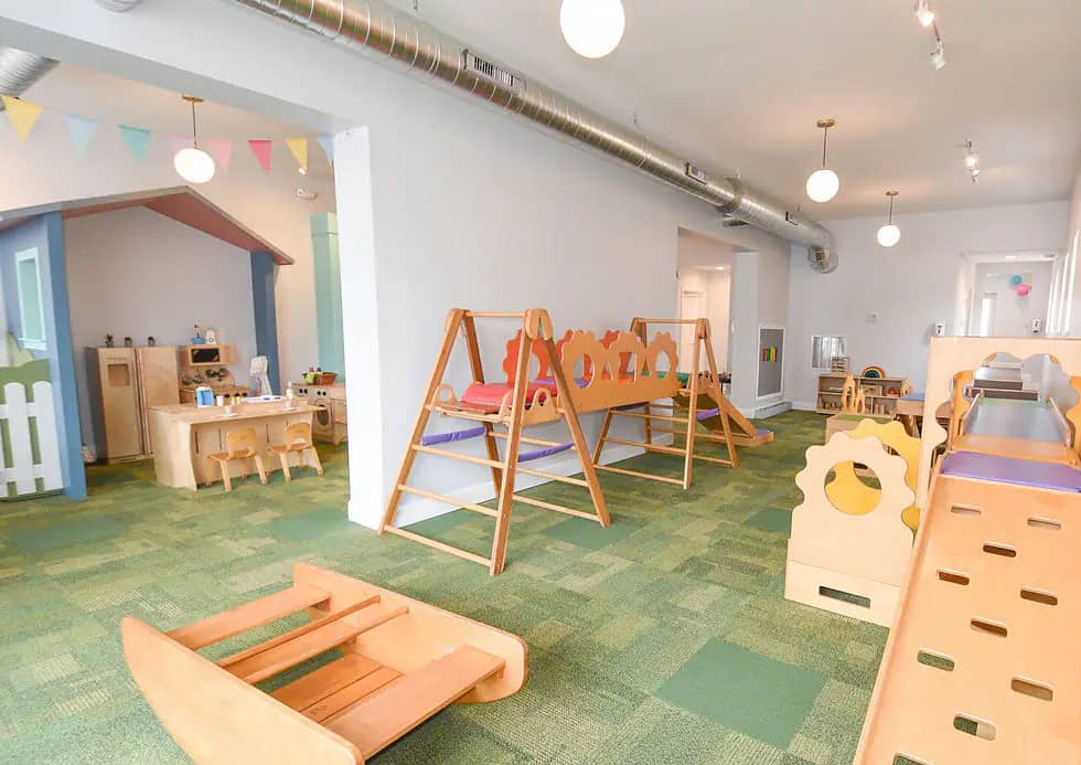 Light-filled play room at Little Buffalo with wooden climbers, curated toys, and space for babies and young children.