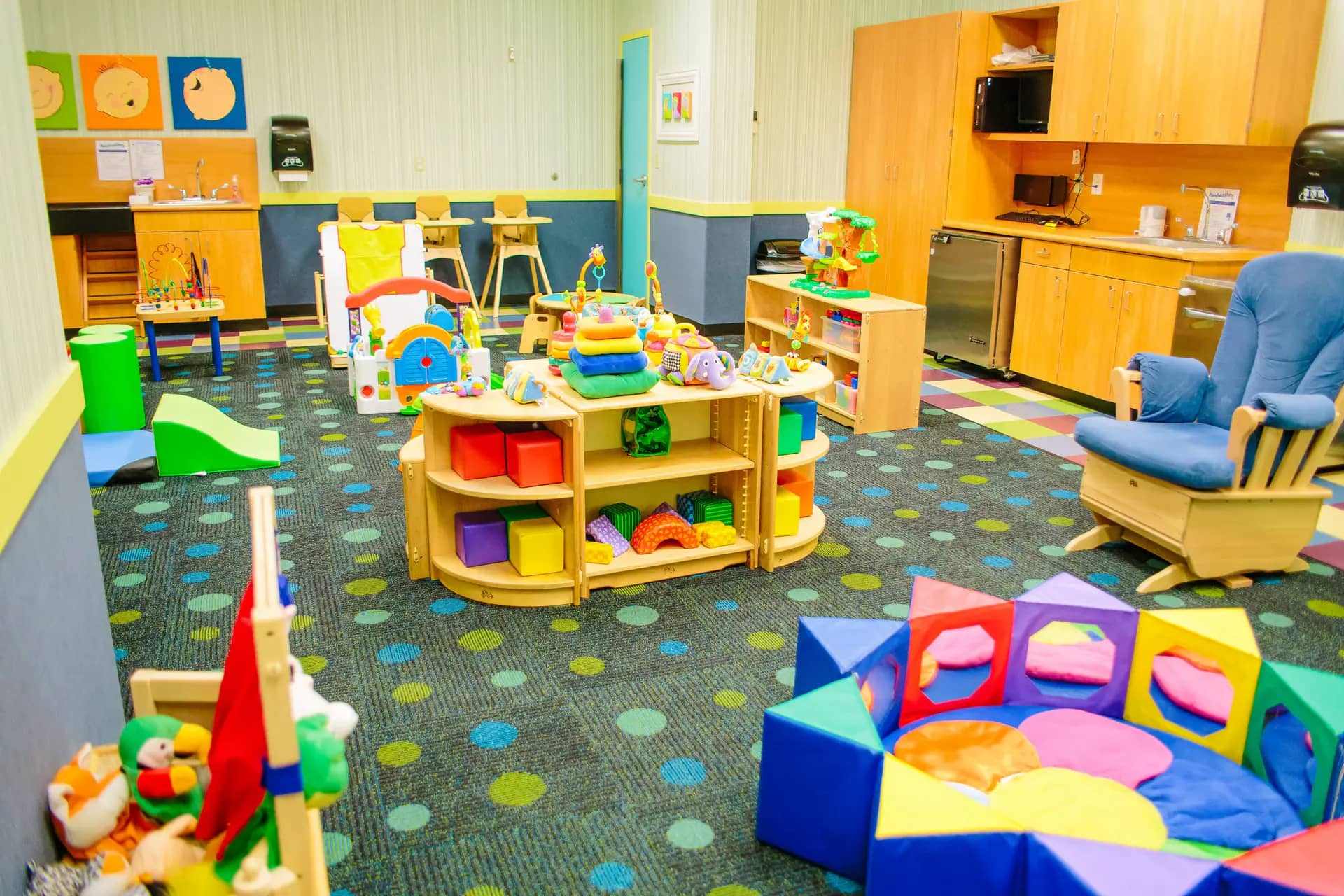 Tiny Tots room at Kids Quest with infant toys, seating, and baby-friendly play equipment.