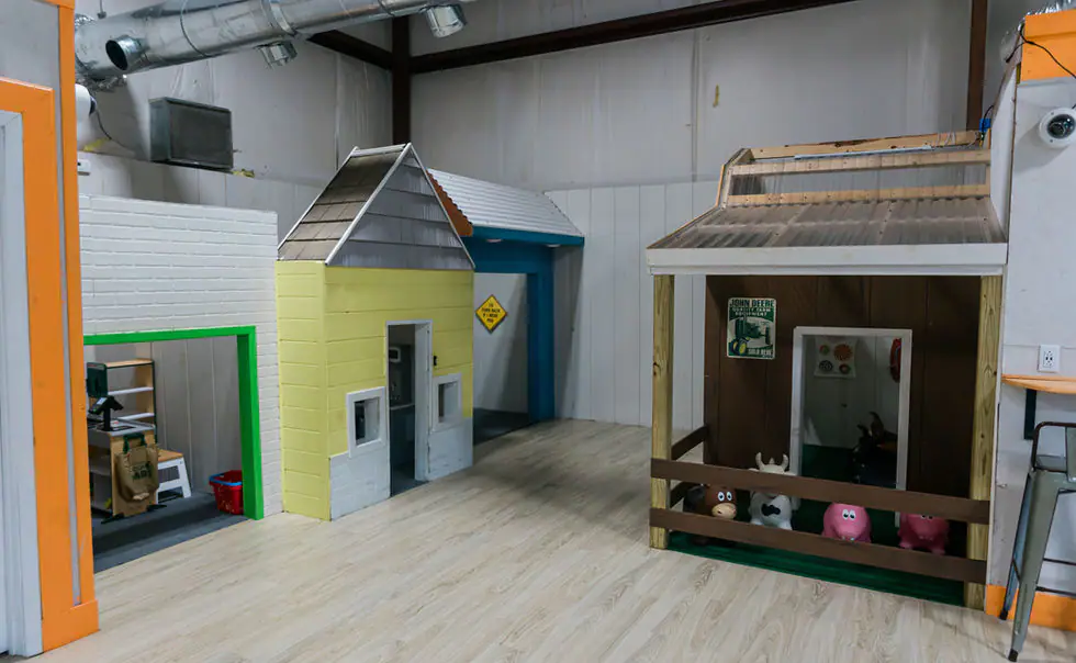 Pretend-play town area with child-sized buildings for younger children at Kid Zone.