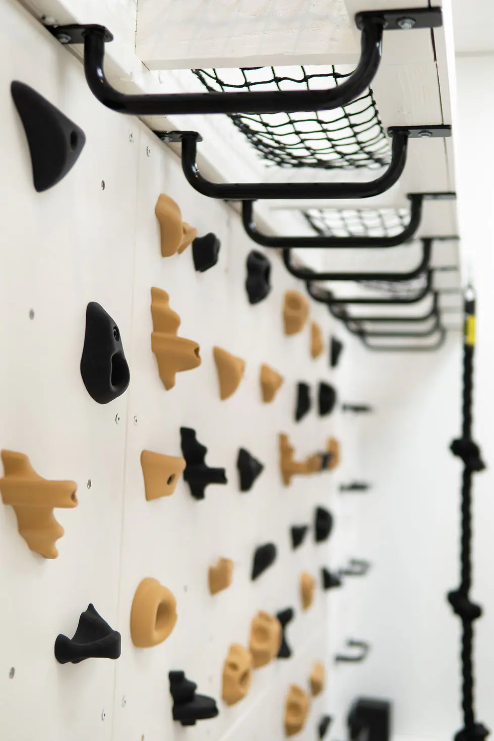 Gross-motor climbing wall and overhead bars at Happy Baby Play.