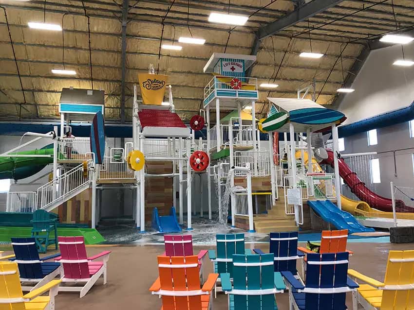 Parent seating facing the central water-play structure at Splash Shack.