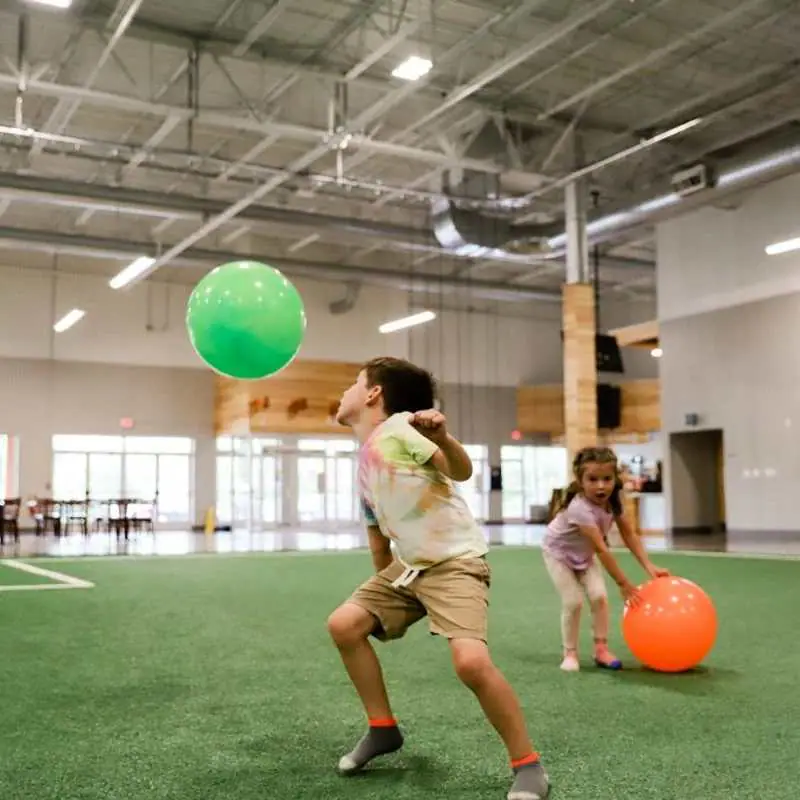 Children playing on indoor turf inside The Point community center.