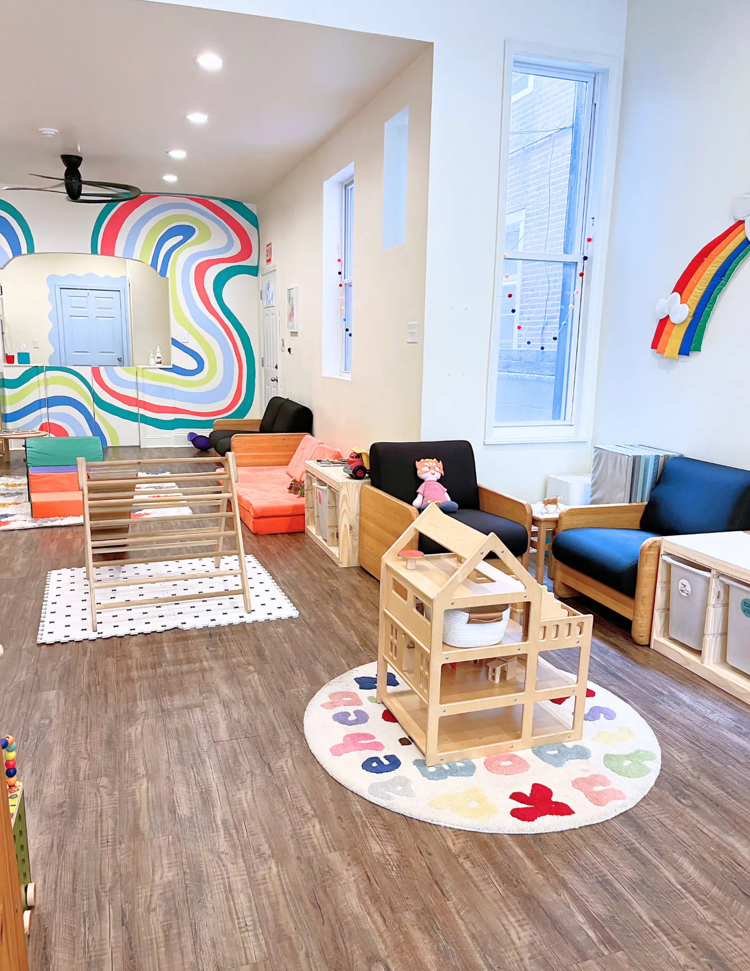 Simple, bright playspace inside Lilypad Philly with small furniture and toddler play elements.
