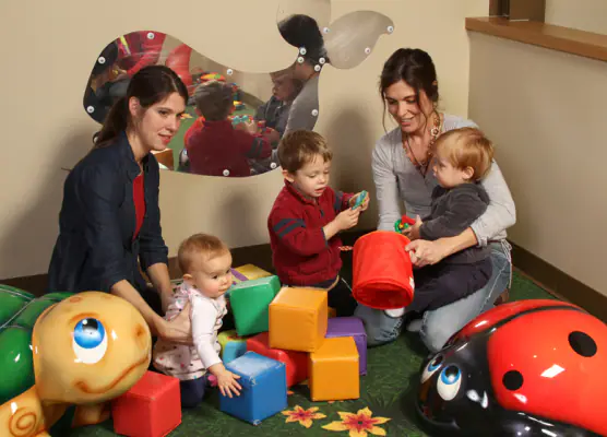 Toddlers and caregivers using a soft toddler play corner at The Children's Play Gallery.