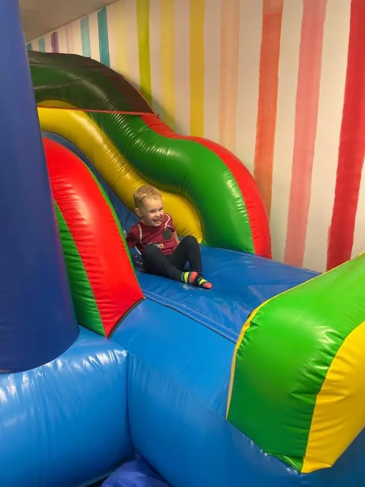 Young child going down a soft indoor slide at Imaginasium.