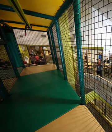 Interior walkway and netted play area inside Holland Playland.